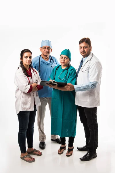 Four Indian doctors discussing on medical report while standing isolated over white background