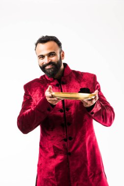 Hint Adam Diwali veya düğün geleneksel Sherwani giyerken boş plaka tutan, beyaz arka plan üzerinde izole ayakta