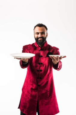 Hint Adam Diwali veya düğün geleneksel Sherwani giyerken boş plaka tutan, beyaz arka plan üzerinde izole ayakta