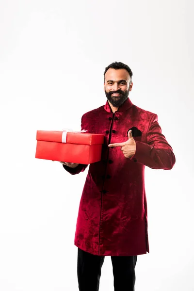 伝統的な服 シャーワニのインドの陽気なひげの男は 白い背景の上にギフトボックスを保持 — ストック写真