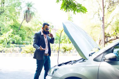 Araç / araba arızalı endişeli Hintli işadamı, telefonda konuşuyor.