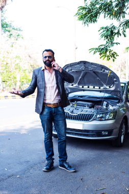 Araç / araba arızalı endişeli Hintli işadamı, telefonda konuşuyor.