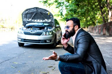 Araç / araba arızalı endişeli Hintli işadamı, telefonda konuşuyor.