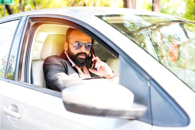 Araba sürerken akıllı telefon kullanan Hint Sakallı işadamı