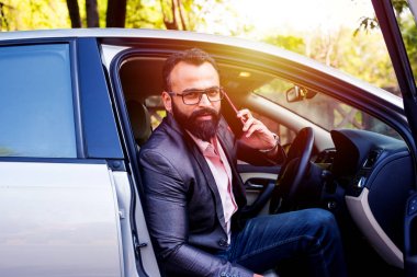 Araba sürerken akıllı telefon kullanan Hint Sakallı işadamı