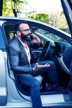 Araba sürerken akıllı telefon kullanan Hint Sakallı işadamı