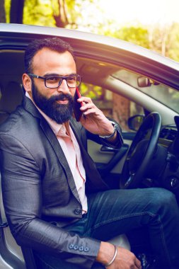 Araba sürerken akıllı telefon kullanan Hint Sakallı işadamı