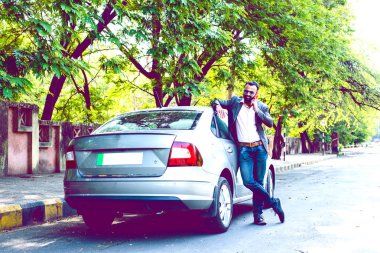 Hint / asyalı genç işadamı arabanın yakınında akıllı telefon kullanarak, dış görünüm. seçici odaklama