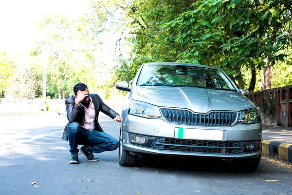 worried Indian Businessman with vehicle/car breakdown, talking on phone