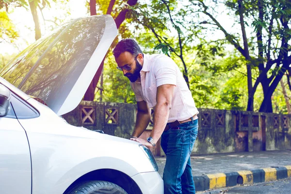 worried Indian Businessman with vehicle/car breakdown, talking on phone