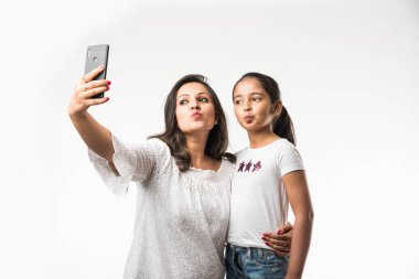 Hint/Asya Anne kızı akıllı telefon ile selfie resmi alarak, beyaz arka plan üzerinde izole