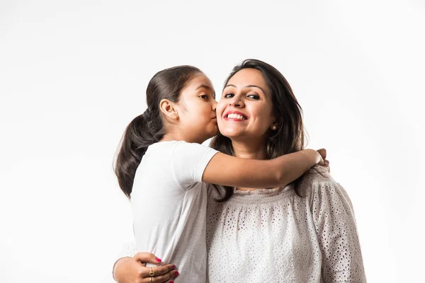 Indian mother daughter on white background hugging, kissing, riding, flying, pointing, presenting over white background