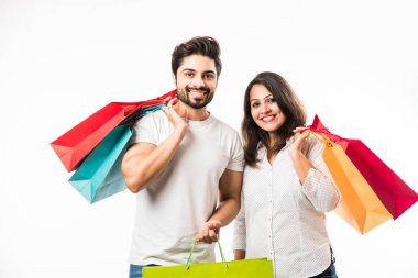 Hintli genç çift alışveriş çantaları, beyaz arka plan üzerinde izole ayakta. seçici odaklama