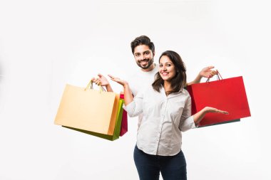 Hintli genç çift alışveriş çantaları, beyaz arka plan üzerinde izole ayakta. seçici odaklama