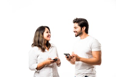 Akıllı telefon / cep telefonu kullanarak Hint çift, beyaz arka plan üzerinde izole ayakta