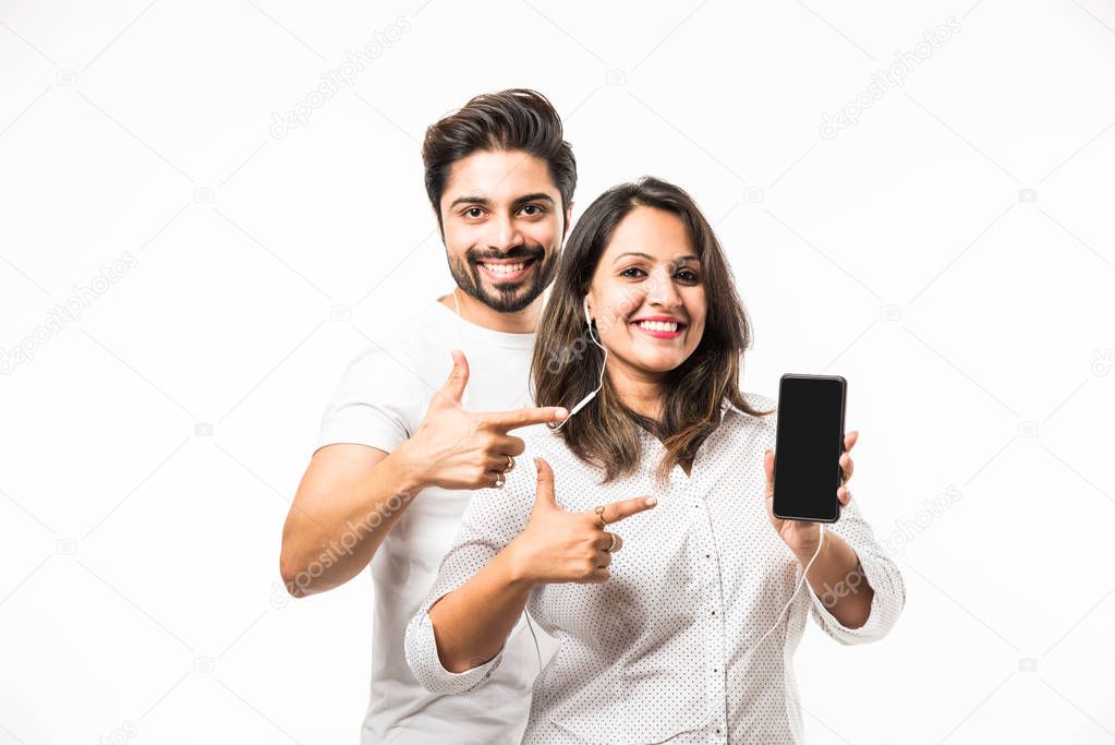 Indian smart couple listen to music on headphones, isolated over white background