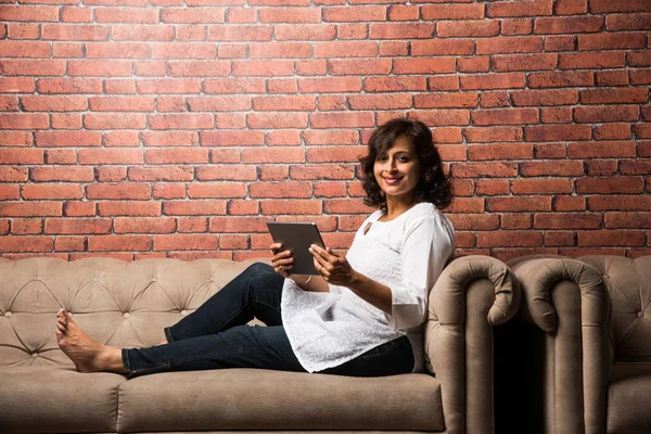 Ινδική Κυρία Γυναίκες Χρησιμοποιώντας Tablet Ενώ Κάθονται Στον Καναπέ Καναπέ — Φωτογραφία Αρχείου