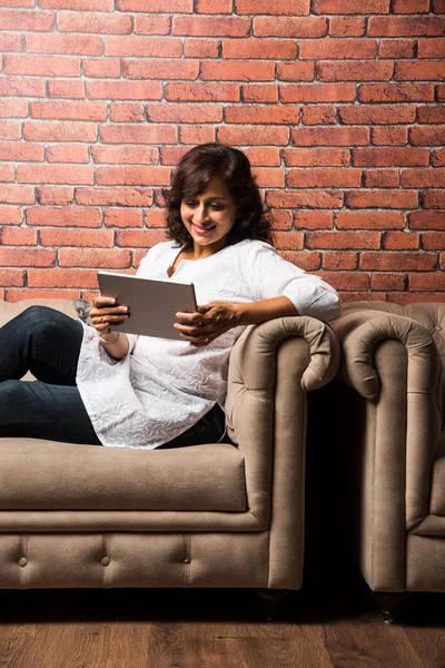 Ινδική Κυρία Γυναίκες Χρησιμοποιώντας Tablet Ενώ Κάθονται Στον Καναπέ Καναπέ — Φωτογραφία Αρχείου