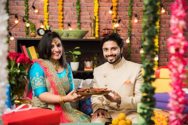 Diwali, Deepavali veya Dipavali festivali kutlarken diya, tatlılar ve hediyeler ile Hint çift