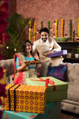 Diwali, Deepavali veya Dipavali festivali kutlarken diya, tatlılar ve hediyeler ile Hint çift