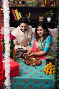 Diwali, Deepavali veya Dipavali festivali kutlarken diya, tatlılar ve hediyeler ile Hint çift