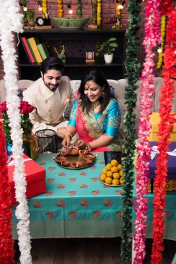 Diwali, Deepavali veya Dipavali festivali kutlarken diya, tatlılar ve hediyeler ile Hint çift