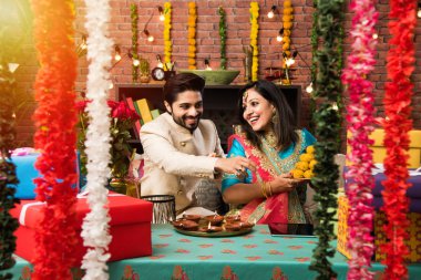 Diwali, Deepavali veya Dipavali festivali kutlarken diya, tatlılar ve hediyeler ile Hint çift