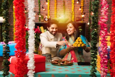 Diwali, Deepavali veya Dipavali festivali kutlarken diya, tatlılar ve hediyeler ile Hint çift