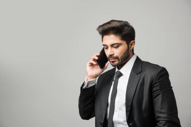 Hintli iş adamı cep telefonu kullanıyor. Sohbet etmek, SMS yazmak veya sunum yapmak