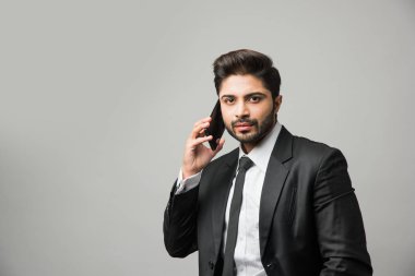 Hintli iş adamı cep telefonu kullanıyor. Sohbet etmek, SMS yazmak veya sunum yapmak