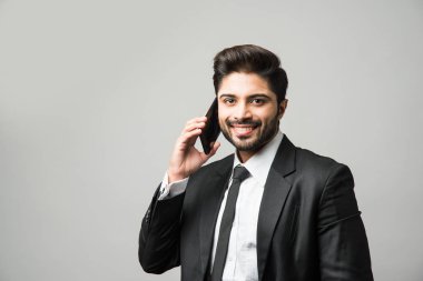 Hintli iş adamı cep telefonu kullanıyor. Sohbet etmek, SMS yazmak veya sunum yapmak