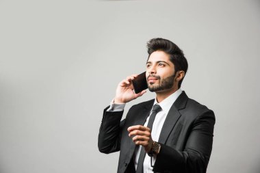 Hintli iş adamı cep telefonu kullanıyor. Sohbet etmek, SMS yazmak veya sunum yapmak