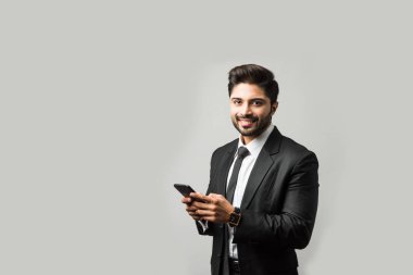 Hintli iş adamı cep telefonu kullanıyor. Sohbet etmek, SMS yazmak veya sunum yapmak