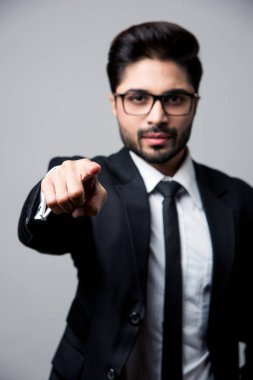 Hintli işadamı seni işaret ediyor, beyaz arka planda tek başına duruyor.