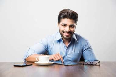 Hintli iş adamı cep telefonu kullanıyor. Sosyal medya beslemelerinin yazılması veya denetlenmesi