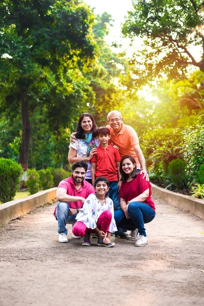 Portrait of Indian Family of six, enjoying Picnic or morning walk - Multi generation of asian family posing at a walkway at park, outdoor. selective focus