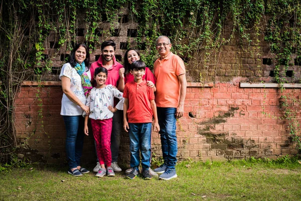 Famiglia Indiana Piedi Fila Contro Muro Coperto Rampicanti Multi Generazione — Foto Stock