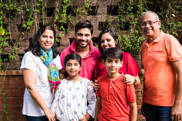 Indiánská Rodina Stojí Řadě Zdi Pokryté Šlahouny Multi Generace Asijské — Stock fotografie