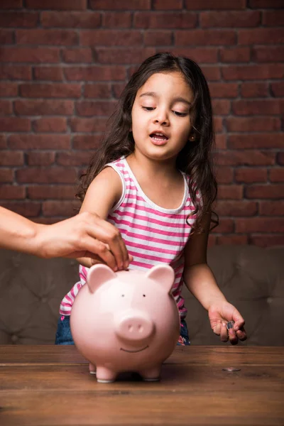 Indian small girl with piggy bank - saving concept