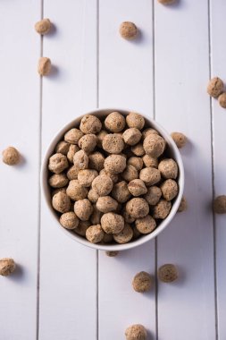 Çiğ Soya Parçacıkları, vejetaryenler için soya eti renkli arka planda bir kasede ya da yığın halinde izole edilmiş.