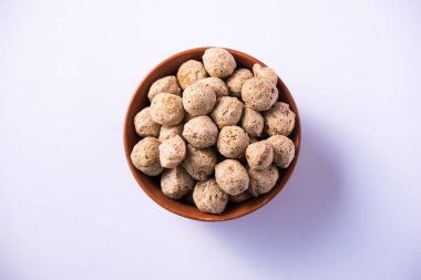 Çiğ Soya Parçacıkları, vejetaryenler için soya eti renkli arka planda bir kasede ya da yığın halinde izole edilmiş.