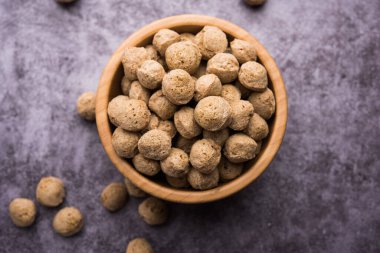 Çiğ Soya Parçacıkları, vejetaryenler için soya eti renkli arka planda bir kasede ya da yığın halinde izole edilmiş.