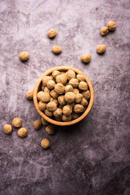 Çiğ Soya Parçacıkları, vejetaryenler için soya eti renkli arka planda bir kasede ya da yığın halinde izole edilmiş.