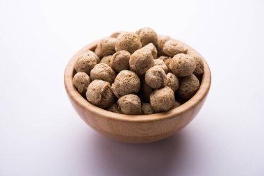 Çiğ Soya Parçacıkları, vejetaryenler için soya eti renkli arka planda bir kasede ya da yığın halinde izole edilmiş.