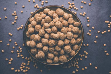 Çiğ Soya Parçacıkları, vejetaryenler için soya eti renkli arka planda bir kasede ya da yığın halinde izole edilmiş.