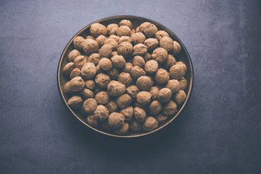 Çiğ Soya Parçacıkları, vejetaryenler için soya eti renkli arka planda bir kasede ya da yığın halinde izole edilmiş.