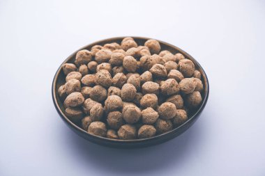 Çiğ Soya Parçacıkları, vejetaryenler için soya eti renkli arka planda bir kasede ya da yığın halinde izole edilmiş.