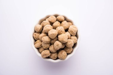 Çiğ Soya Parçacıkları, vejetaryenler için soya eti renkli arka planda bir kasede ya da yığın halinde izole edilmiş.