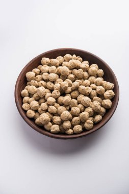 Çiğ Soya Parçacıkları, vejetaryenler için soya eti renkli arka planda bir kasede ya da yığın halinde izole edilmiş.