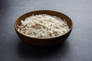 Çiğ pirinç ya da ince pirinç gevreği Namkeen Chivda atıştırmalıkları için ya da Hint kahvaltısı için Aloo Poha, bir kase içinde servis edilir.